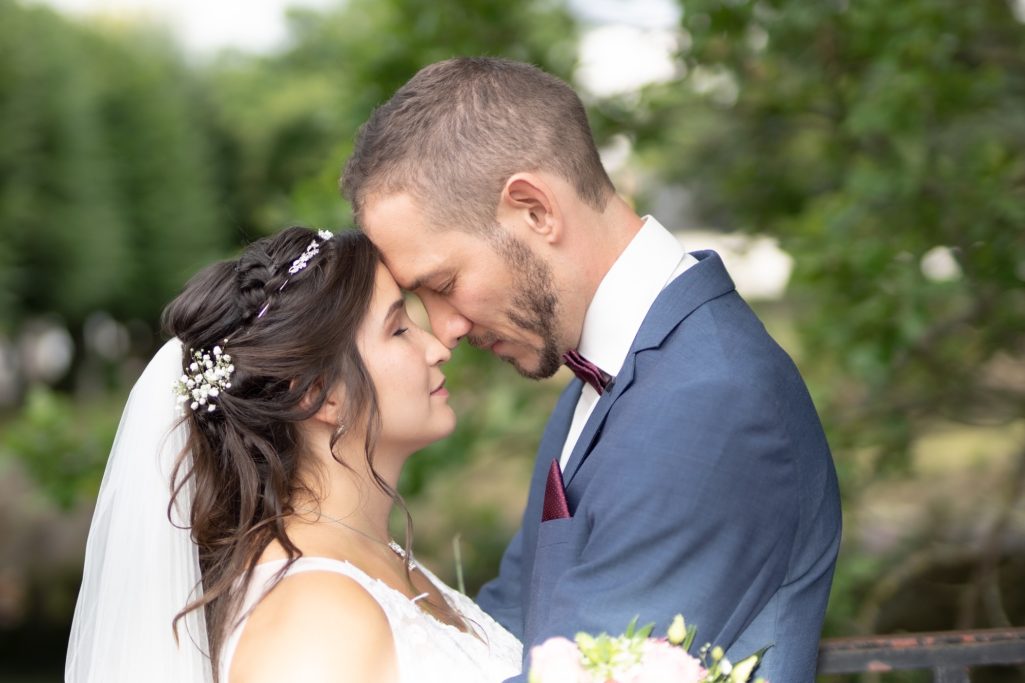 Braut und Bräutigam stehen sich nah gegenüber, einander in die Augen blickend.