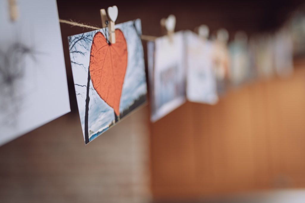 Eine Wäscheleine mit Fotos und einem roten Herz aus Karton.