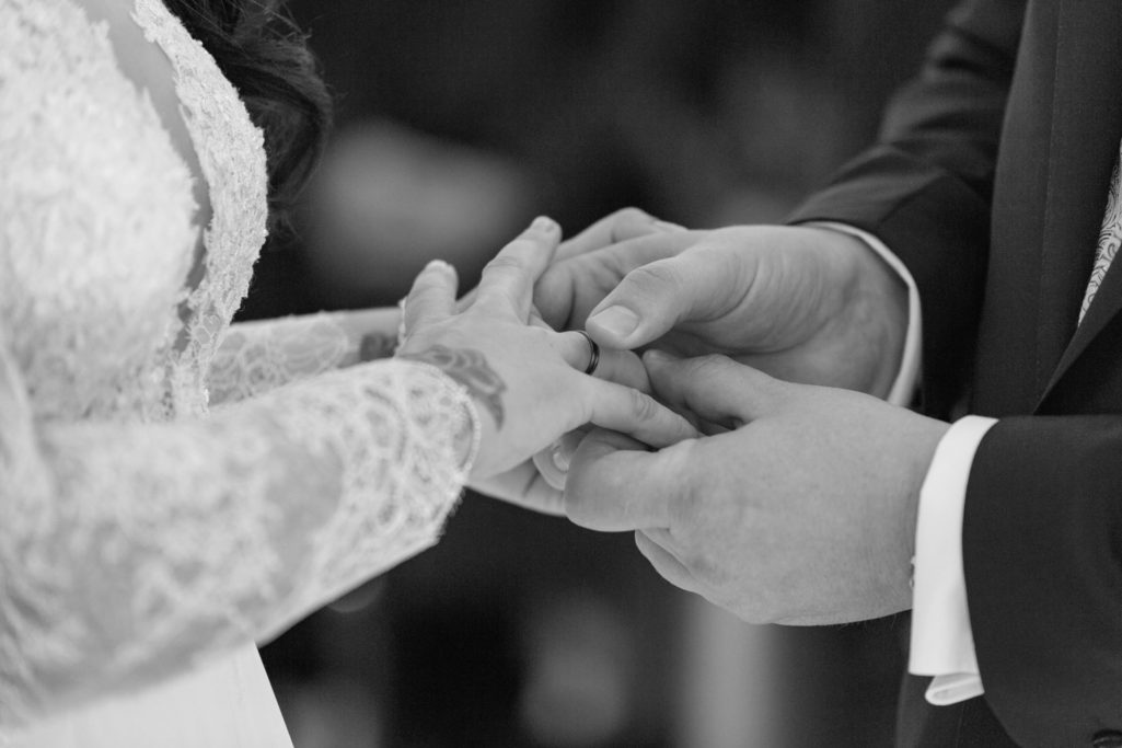 Händchenhalten während einer Hochzeitszeremonie, Ringe werden angesteckt.