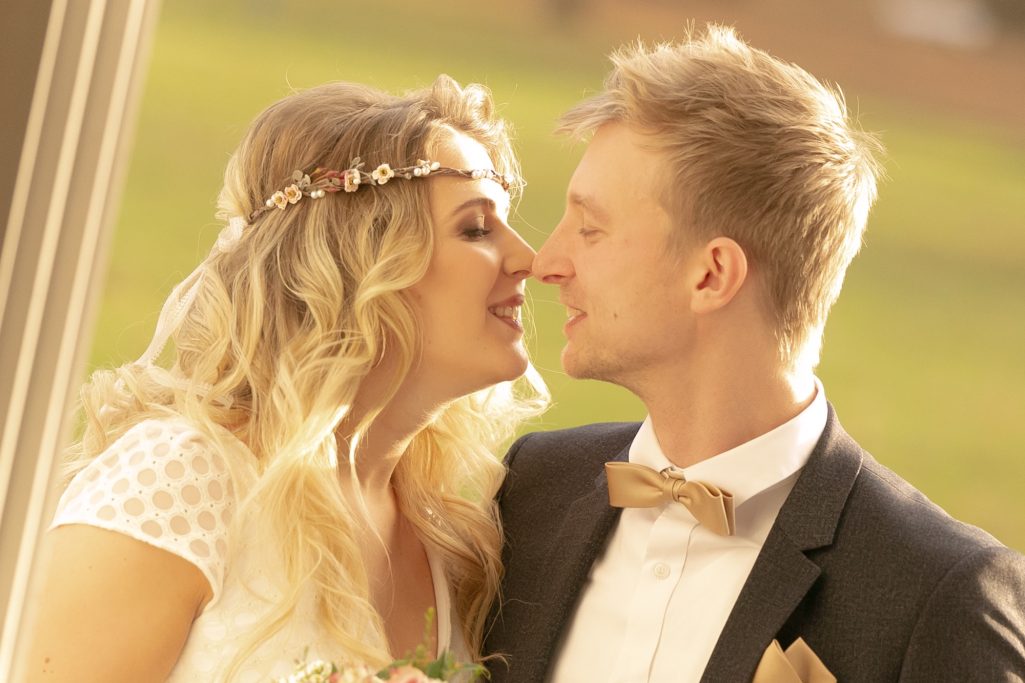 Ein Brautpaar steht sich nah gegenüber und lächelt sich liebevoll an.